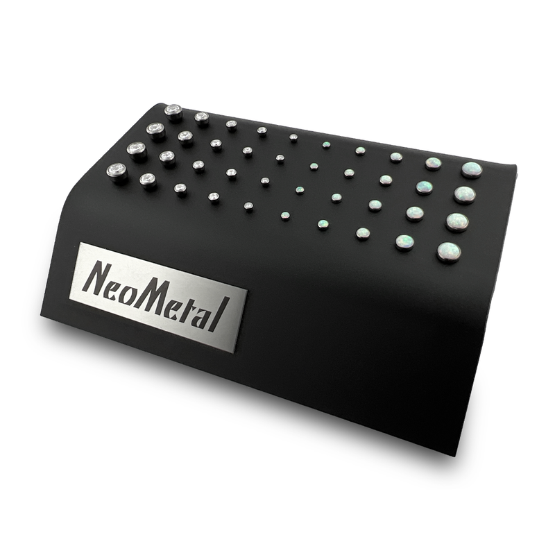 A 40 unit black display case showcasing different sizes of our titanium bezel set cabochon gem ends with cubic zirconia and opal gems