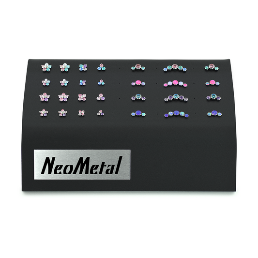 A black acrylic gem display with NeoMetal logo featuring a variety of the Dreamland titanium gem end products.
