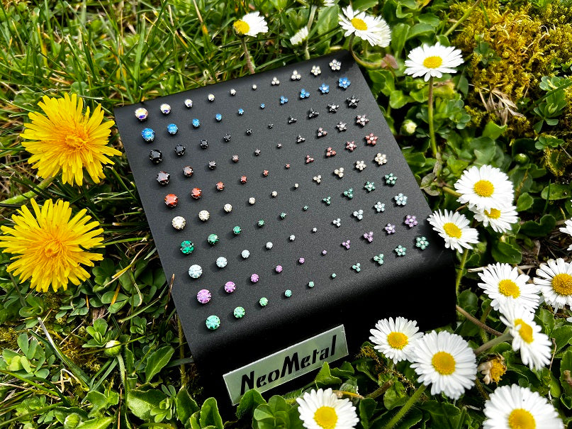 100 piece black acrylic display case with NeoMetal logo featuring many colors and sizes of threadless titanium gem ends.