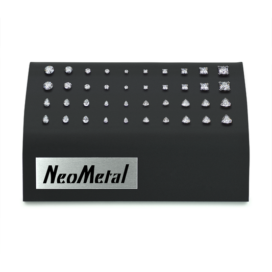 A black acrylic gem display with NeoMetal logo featuring one of each size of the Prong Set Faceted Gem Ends, Princess Cut Gem Ends, Pear Cut Gem Ends, and Trillion Cut Gem Ends with Cubic Zirconia Gems.