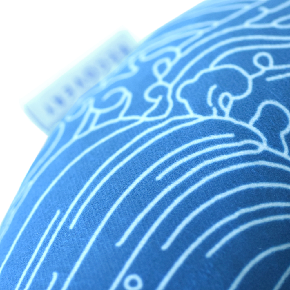 Close up of Blue Piercing Pillow with white wave outlines