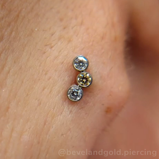 A 3-piece curved cluster featuring 1.5mm Cubic Zirconia and Champagne Faceted Gems in threadless titanium bezel settings