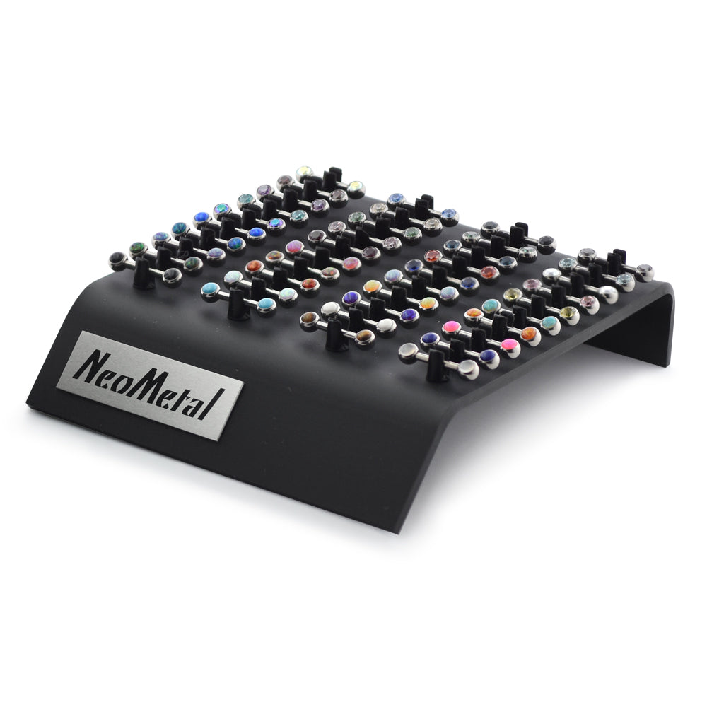 A 40 piece acrylic display case with the NeoMetal logo and versi-clip grips. The versi clips hold threadless titanium nipple bars with a variety of colored gem ends.