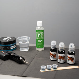 Bottle of Recovery Aftercare soap with other tattoo supplies