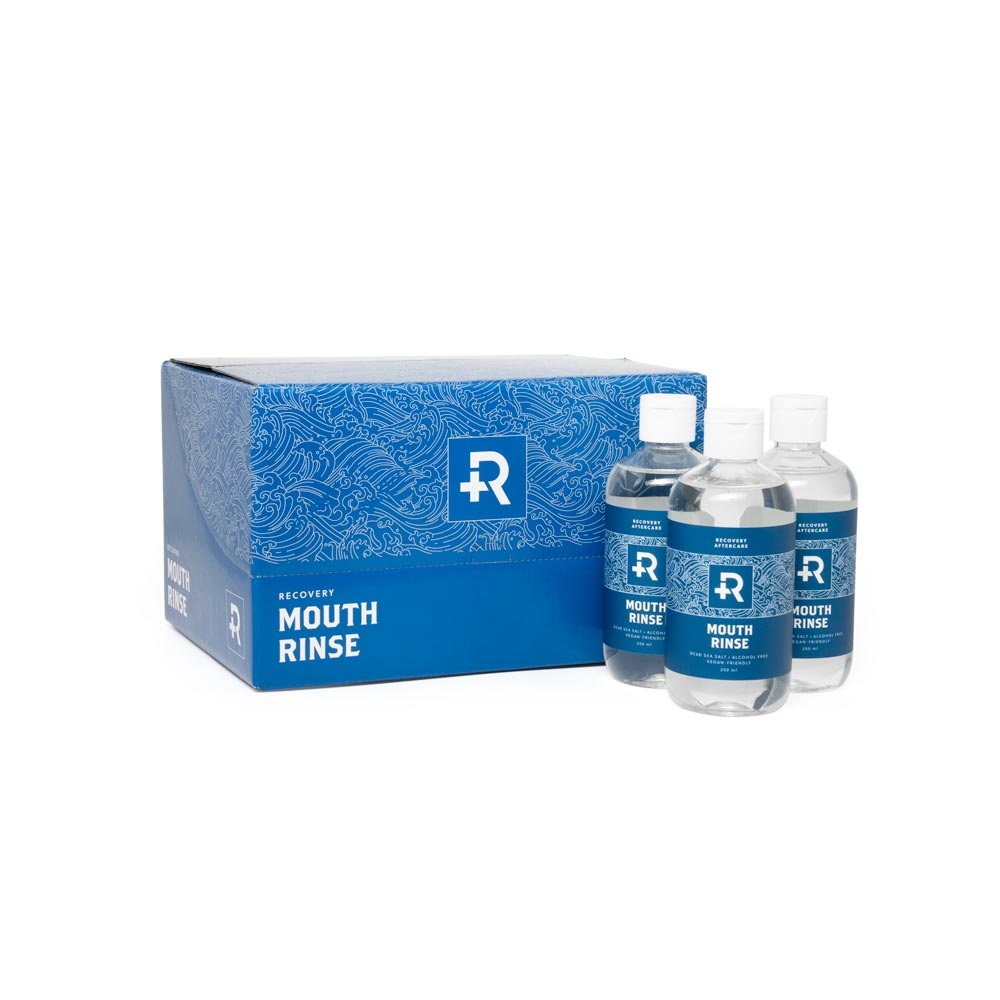Back of retail packaging of 12 bottles of Recovery Aftercare Sea Salt Mouth Rinse and three bottles in front of the box
