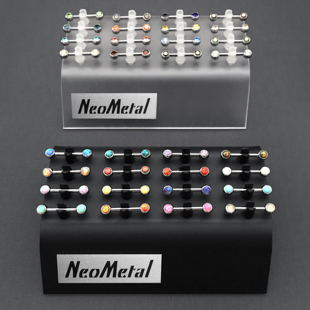 A 16 piece black acrylic display case and clear acrylic display case with the NeoMetal logo and versi-clip grips. The versi clips hold threadless titanium nipple bars with a variety of colored gem ends.