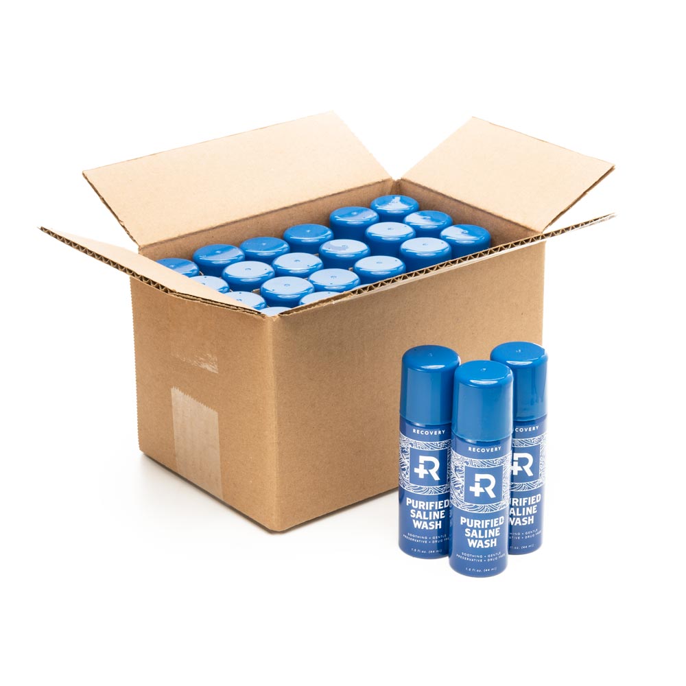 Open box of 24 cans of Recovery Purified Saline Wash Spray with 3 cans in front
