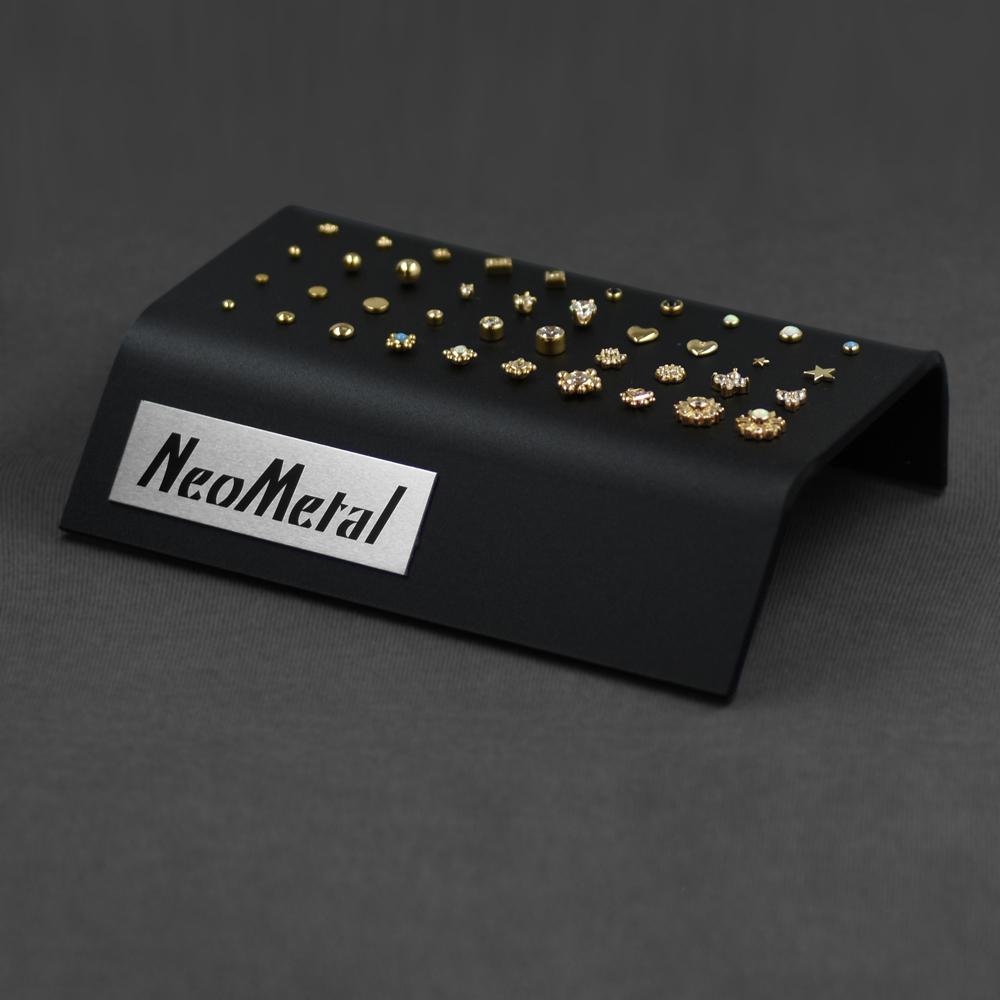 A 40 piece clear acrylic display case with the NeoMetal logo and a variety of gold gem ends.