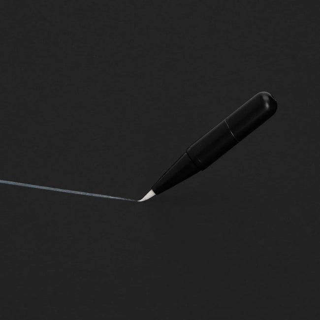 A mini surgical skin marker being used on a black background